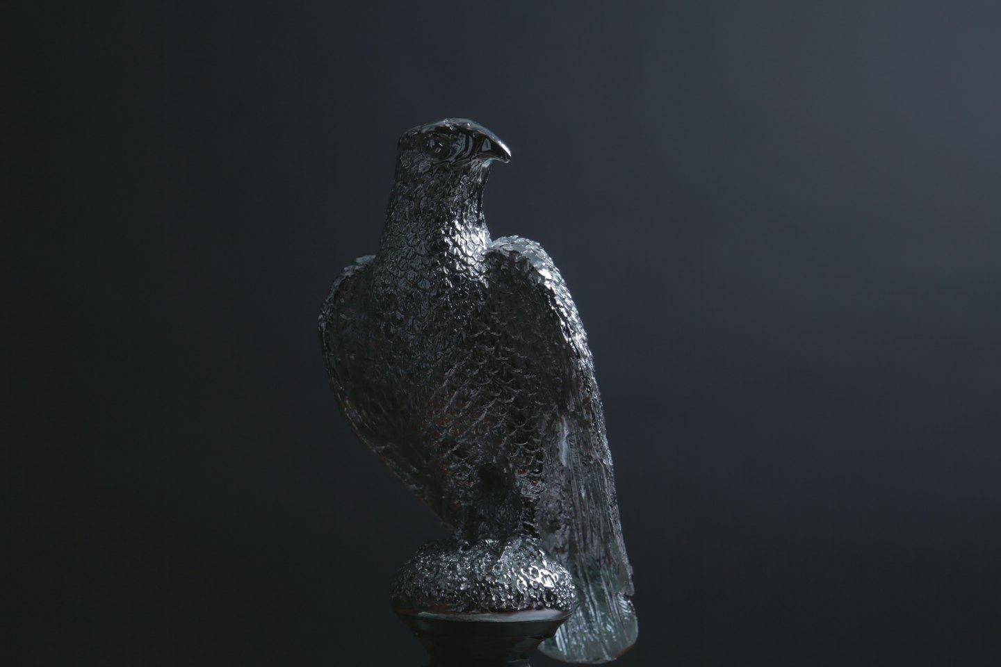 A sculpted dark eagle statue standing against a plain background.